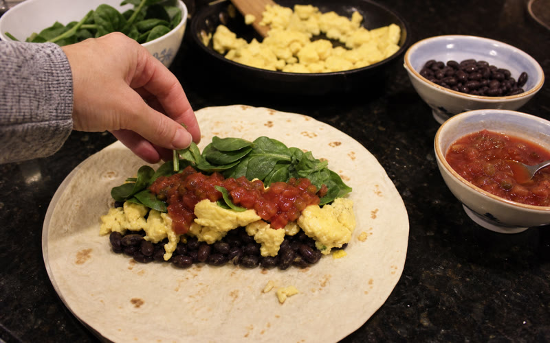 Beans, eggs, spinach and salsa layered onto the tortilla