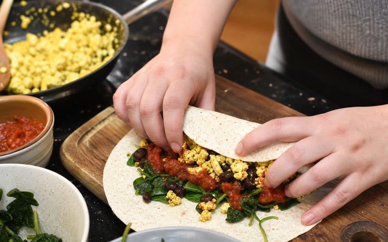 Rolling the breakfast burrito tight enough to hold together