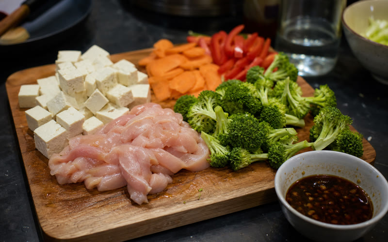 Tofu, chicken, vegetables and sauce prepped before the wok goes on